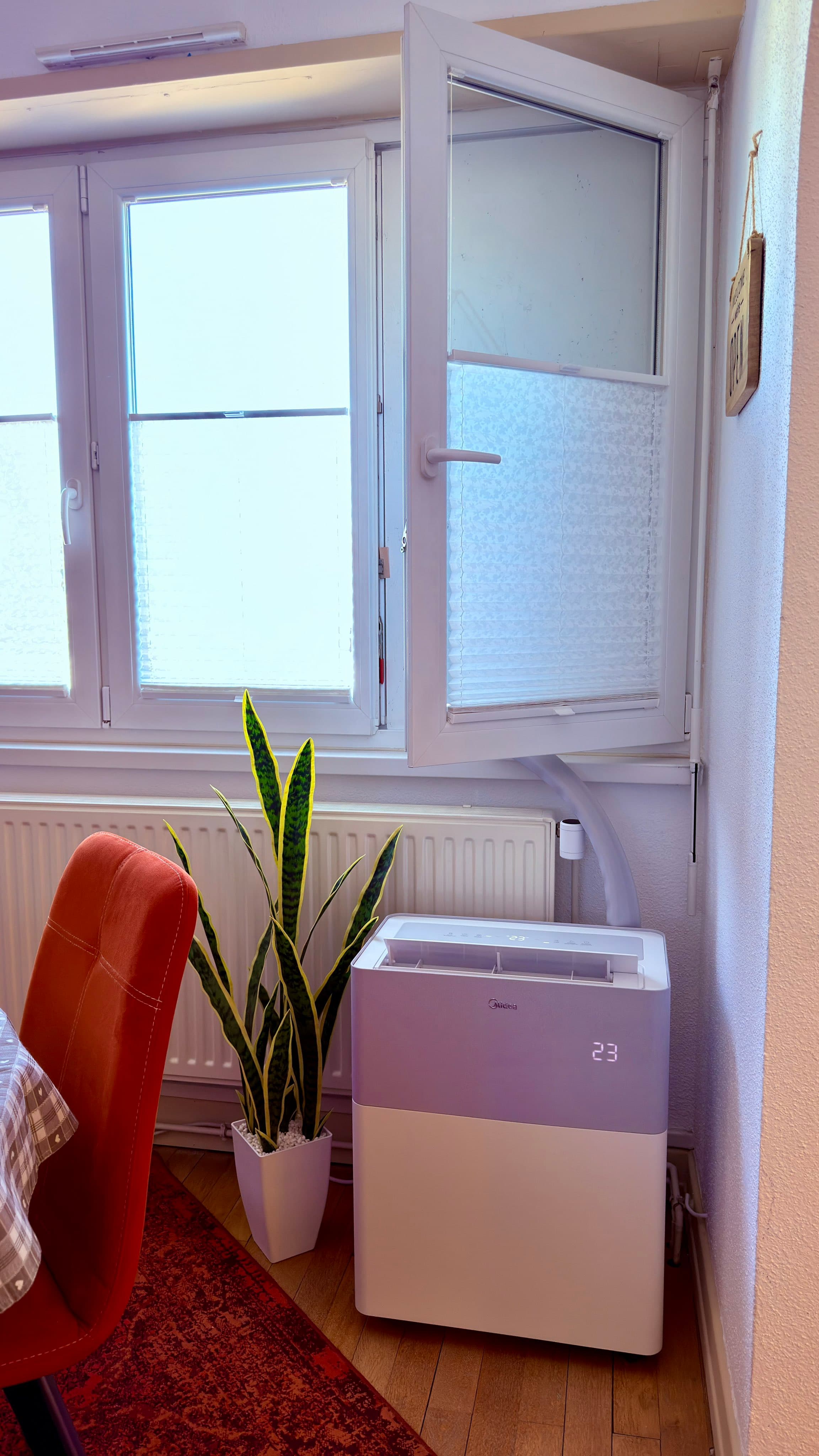 Midea PortaSplit installée dans un séjour, gaine passée par la fenêtre, afficheur sur 23 degrés