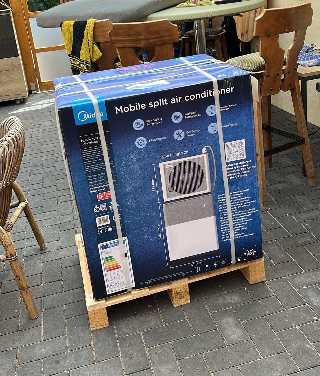 Carton Midea PortaSplit sur sa palette, livré sur une terrasse